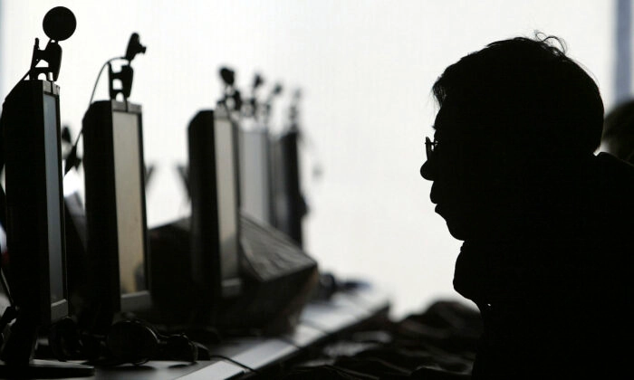 Um usuário de computador é visto com uma fileira de monitores de computador em um cibercafé em Shenyang, Liaoning, em 28 de janeiro de 2008 (AP Photo)
