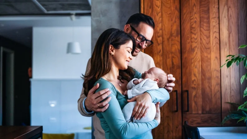 Um pai e uma mãe com seu bebê recém-nascido em casa (Shutterstock/NDAB Creativity)
