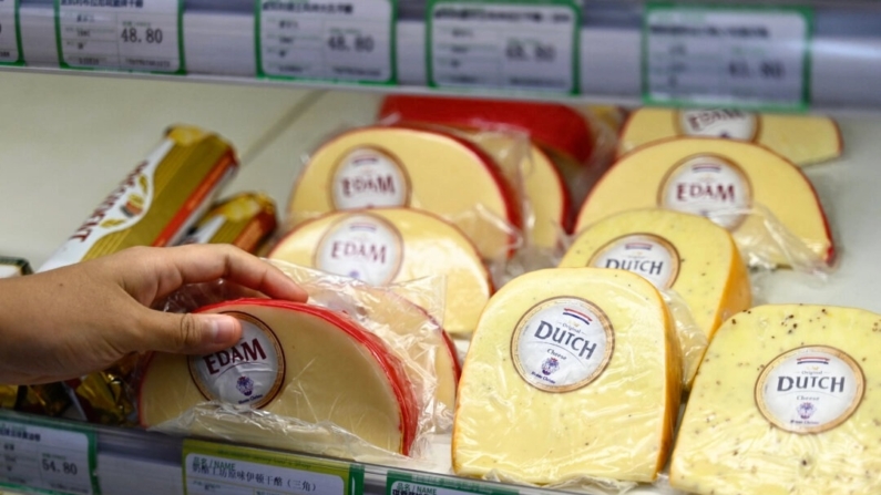 Um cliente pega um queijo importado da Europa em um supermercado em Pequim, em 21 de agosto de 2024 (Pedro Pardo/AFP via Getty Images)