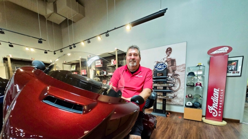 Quinn Keefe, gerente de marketing da Indian Motorcycle Peoria, senta-se em uma Scout, um dos modelos mais populares da concessionária, em Peoria, Arizona, em 21 de agosto de 2024 (Allan Stein/Epoch Times)