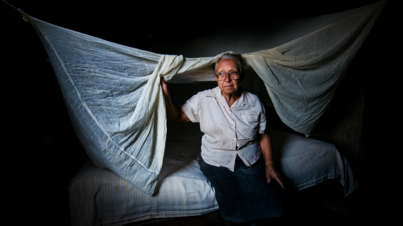 Uma mulher idosa se senta em sua cama em Holguin, Cuba, em 27 de abril de 2012 (STR/AFP/GettyImages)