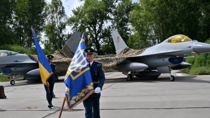 Militares ucranianos carregam bandeiras após uma cerimônia realizada para marcar o Dia das Forças Aéreas Ucranianas em uma área não revelada em 4 de agosto de 2024 (Sergei Supinsky/AFP)