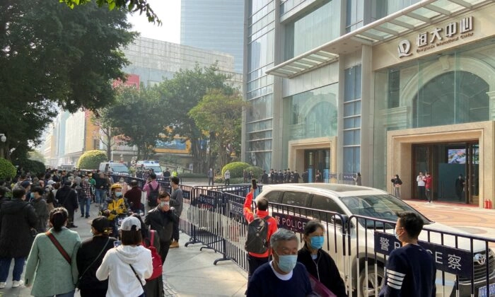 Manifestantes que buscam pagamento do Grupo China Evergrande se reúnem enquanto policiais montam guarda do lado de fora do Centro Internacional Evergrande em Guangzhou, província de Guangdong, China, em 4 de janeiro de 2022 (David Kirton/Reuters)
