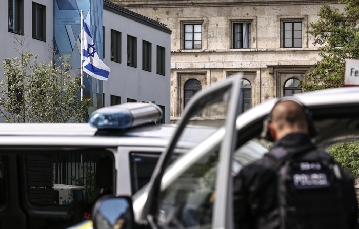 Uma bandeira israelense é hasteada em frente ao prédio do Consulado Geral de Israel enquanto policiais protegem a área após um tiroteio perto do prédio do Centro de Documentação NS para a História do Nacional Socialismo em Munique, Alemanha, em 5 de setembro de 2024 (EFE/EPA/ANNA SZILAGYI)
