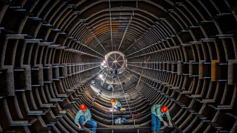 Funcionários trabalham em uma linha de produção de torre de tubo de aço em uma fábrica em Haian, província de Jiangsu, China, em 1º de setembro de 2024. STR/AFP via Getty Images
