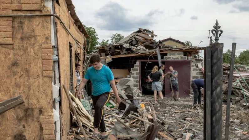 Moradores limpam escombros ao lado de casas fortemente danificadas após bombardeios em Pokrovsk, região leste de Donetsk, em 24 de junho de 2024. Roman Pilipey/AFP via Getty Images
