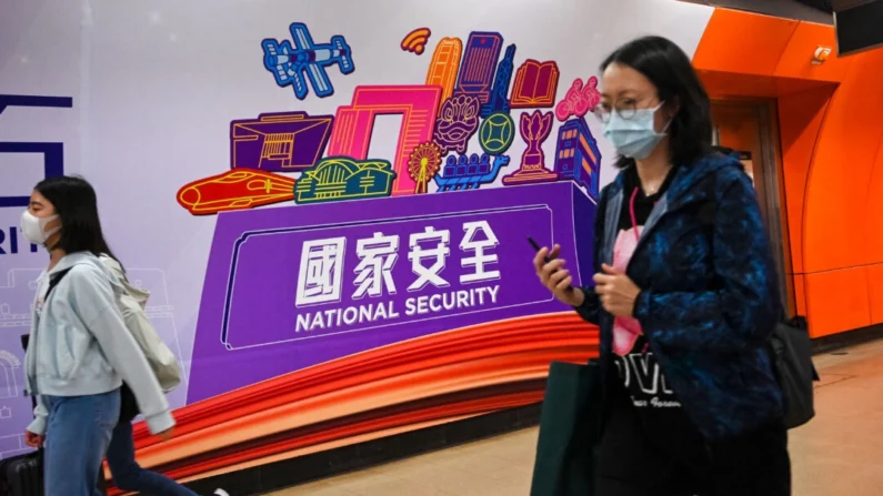 Pessoas passam por uma faixa de Segurança Nacional em uma estação de trem no Dia da Educação para a Segurança Nacional em Hong Kong, em 15 de abril de 2023. Peter Parks/AFP via Getty Images