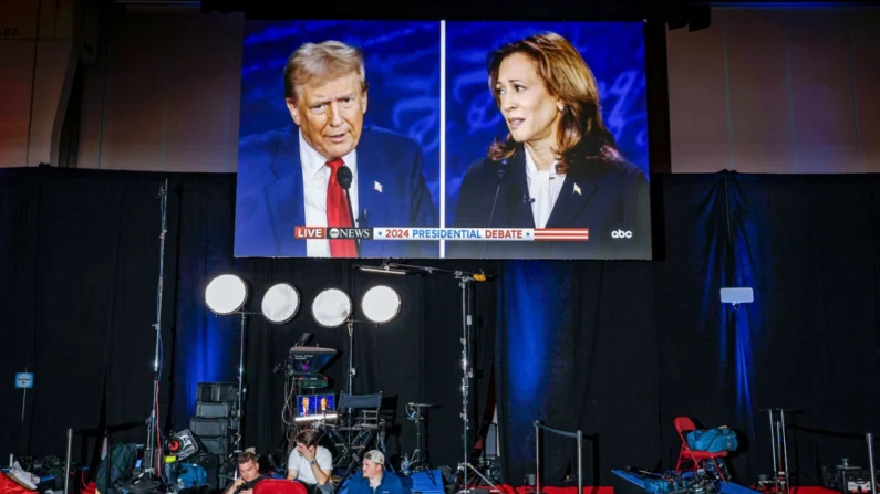 O candidato presidencial republicano, o ex-presidente Donald Trump, e a candidata presidencial democrata, a vice-presidente Kamala Harris, são vistos em telas no centro de mídia do Centro de Convenções da Pensilvânia, na Filadélfia, em 10 de setembro de 2024. Chip Somodevilla/Getty Images
