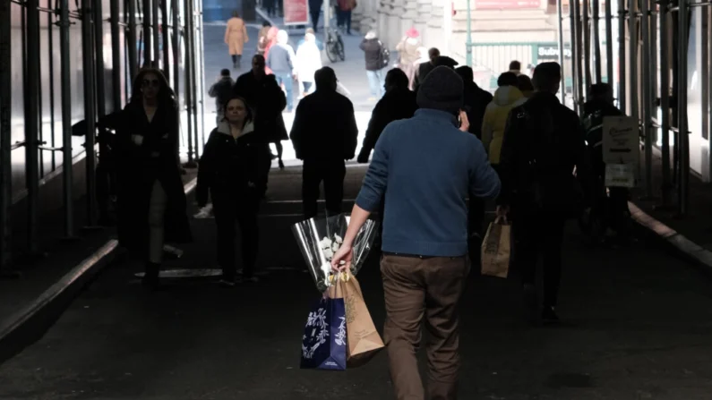 Um homem carrega uma sacola de compras por uma rua de Manhattan, Nova York, em 14 de fevereiro de 2023. (Imagens de Spencer Platt/Getty)