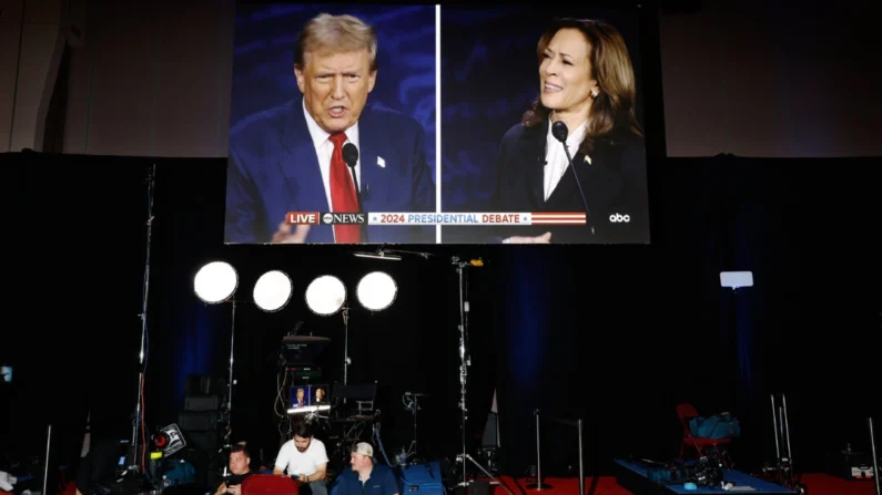 O candidato presidencial republicano, ex-presidente Donald Trump e a candidata presidencial democrata, vice-presidente Kamala Harris, são vistos em telas no centro de mídia do Pennsylvania Convention Center em 10 de setembro de 2024. Chip Somodevilla/Getty Images
