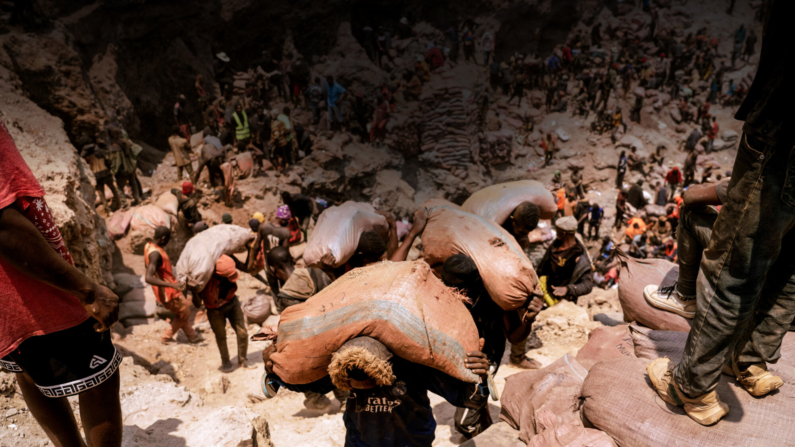 Mineiros artesanais carregam sacos de minério na mina artesanal de Shabara, perto de Kolwezi, República Democrática do Congo, em 12 de outubro de 2022. Junior Kannah/AFP via Getty Images
