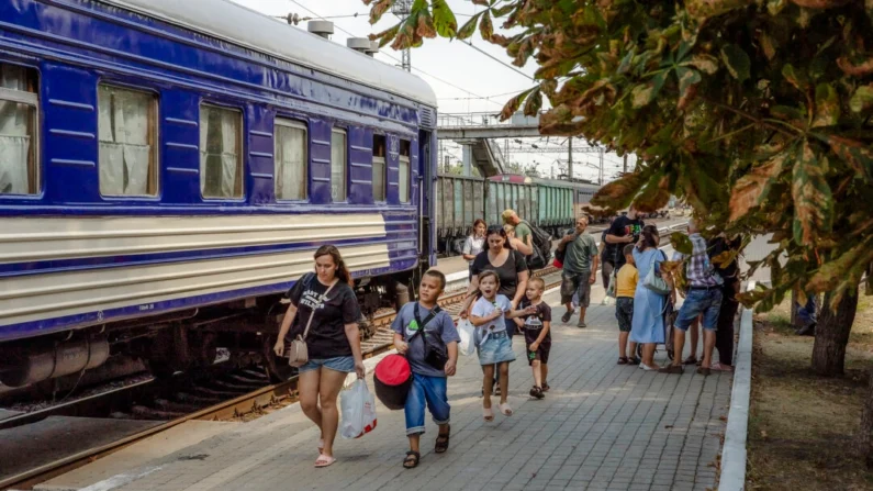 Mulheres com filhos caminham para embarcar num trem de evacuação em Pokrovsk, região oriental de Donetsk, em 2 de agosto de 2024, em meio à invasão russa da Ucrânia. Roman Pilipey/AFP via Getty Images
