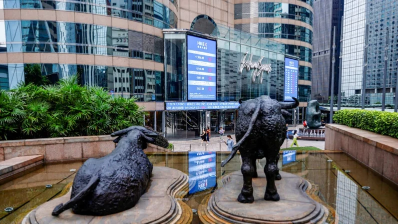 Estátuas de touro são colocadas em frente a telas mostrando o índice de ações Hang Seng e os preços das ações do lado de fora da Exchange Square, em Hong Kong, em 18 de agosto de 2023. Tyrone Siu/Reuters