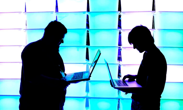 Participantes seguram seus laptops em frente a uma parede iluminada no congresso anual de hackers de computador do Chaos Computer Club (CCC), chamado 29C3, em 28 de dezembro de 2012 em Hamburgo, Alemanha. Patrick Lux/Getty Images
