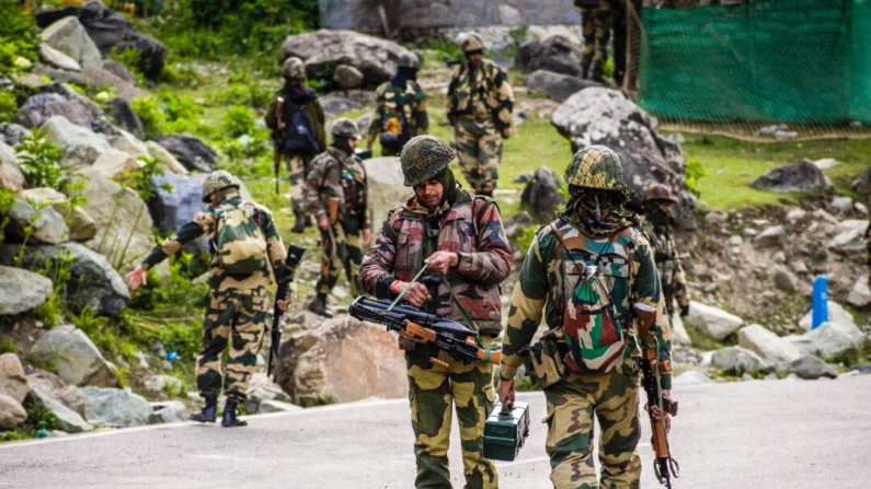 Tropas da Força de Segurança da Fronteira da Índia em patrulha enquanto um comboio do exército indiano passa em uma rodovia que leva a Leh, na fronteira com a China, em Gagangir, Índia, em 19 de junho de 2020. Yawar Nazir/Getty Images