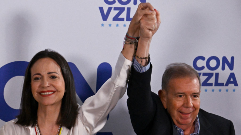 A líder da oposição venezuelana, Maria Corina Machado, de mãos dadas com o candidato presidencial da oposição, Edmundo Gonzalez Urrutia, em Caracas, em 29 de julho de 2024, um dia após a eleição presidencial venezuelana (Foto: JUAN BARRETO/AFP via Getty Images)