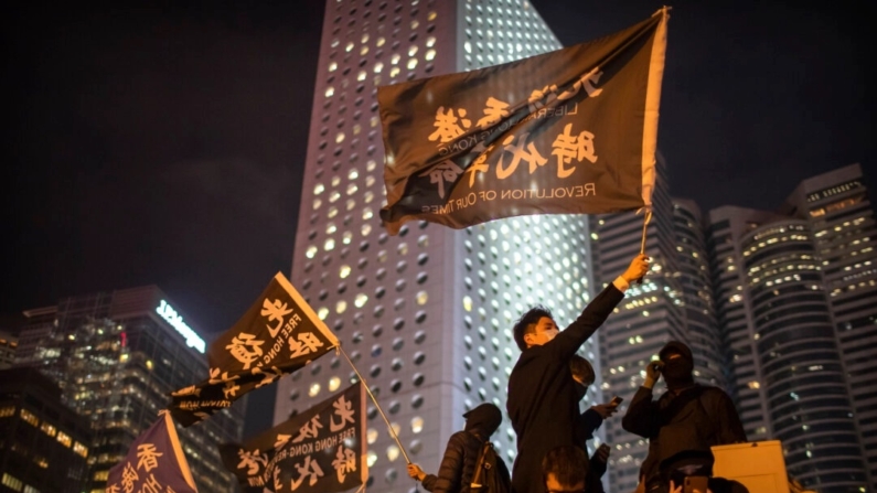 Um manifestante segura uma bandeira com os dizeres: "Libertar Hong Kong, Revolução dos Nossos Tempos" em uma manifestação em Hong Kong, em 12 de dezembro de 2019. (Mark Schiefelbein/AP Photo)