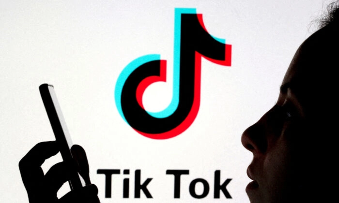 Uma pessoa segura um smartphone enquanto um logotipo do TikTok é exibido atrás nesta ilustração de imagem tirada em 7 de novembro de 2019. Dado Ruvic/Reuters
