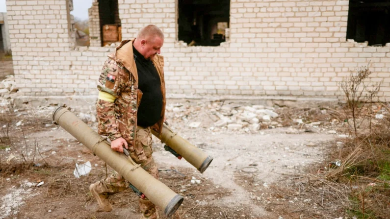 Um militar ucraniano carrega lançadores de granadas antitanque capturados em uma antiga posição de soldados russos na vila de Blahodatne, na região de Kherson, Ucrânia, em 11 de novembro de 2022. Valentyn Ogirenko/Reuters
