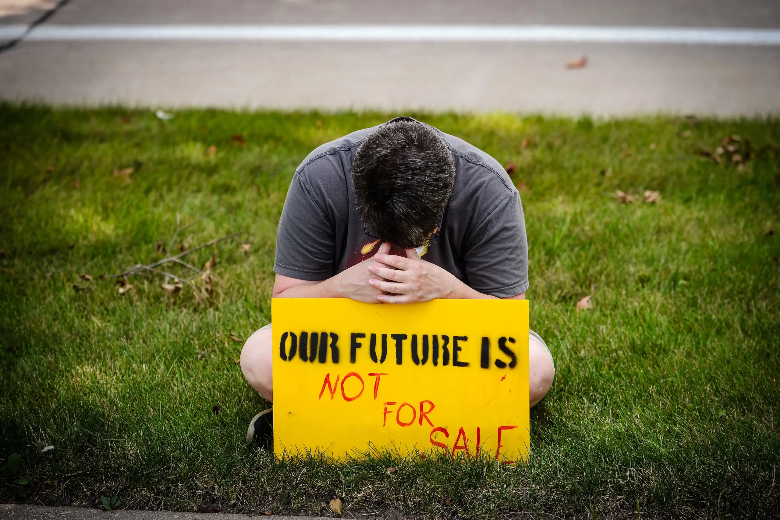 Um manifestante segura um cartaz em um comício para #SealTheDeal for Climate, Jobs, Care, and Justice em Champaign, Illinois, em 19 de agosto de 2021. (Daniel Boczarski/Getty Images para a Green New Deal Network)