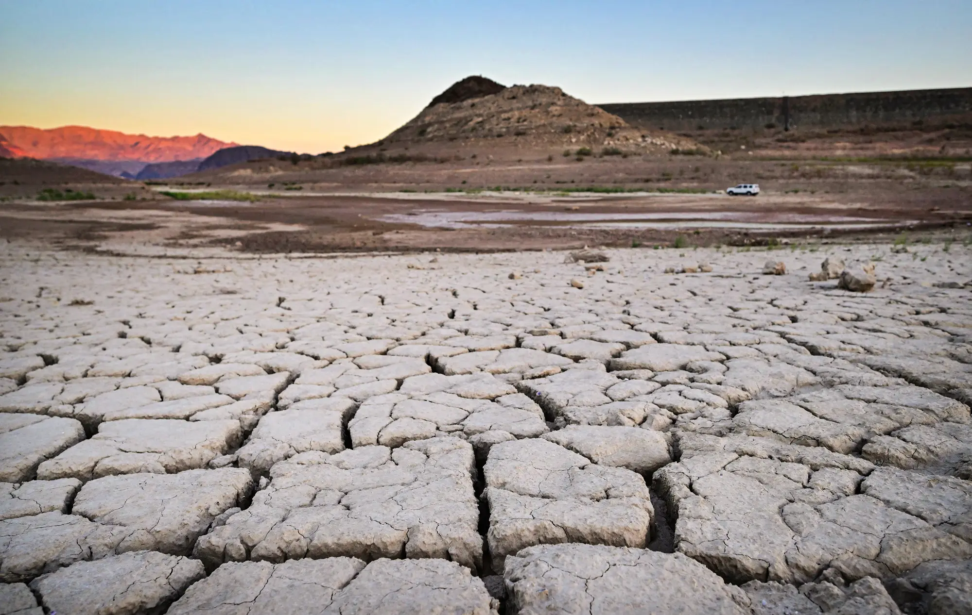 Um veículo passa por um leito de lago seco e rachado na área do Lake Mead, atingida pela seca, em Boulder City, Nevada, em 15 de setembro de 2022. (Frederic J. Brown/AFP via Getty Images)