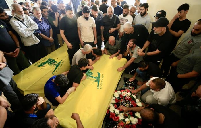 Pessoas se reúnem ao redor de caixões com bandeiras do grupo terrorista Hezbollah, durante uma procissão fúnebre, em Sidon, no sul do Líbano, em 24 de setembro de 2024 (EFE/STR)