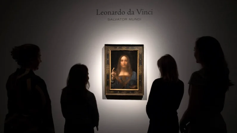 Membros da equipe posam ao lado de uma pintura de Leonardo da Vinci intitulada "Salvator Mundi" antes de ser leiloada em Nova Iorque em 15 de novembro, na Christie’s, em Londres, Inglaterra, em 24 de outubro de 2017 (Carl Court/Getty Images)
