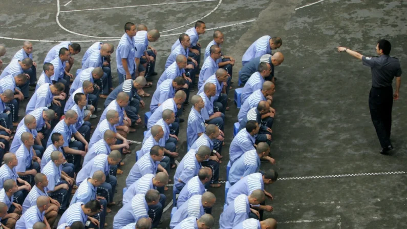 Detentos durante uma sessão de treinamento comportamental na Prisão de Chongqing, em Chongqing, China, em 30 de maio de 2005. China Photos/Getty Images

