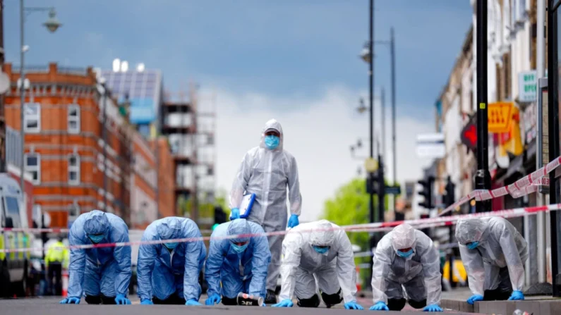 Policiais forenses procuram evidências após um tiroteio do lado de fora de um café que feriu uma menina de 9 anos em Dalston, leste de Londres, em 30 de maio de 2024 (James Manning/PA Wire)
