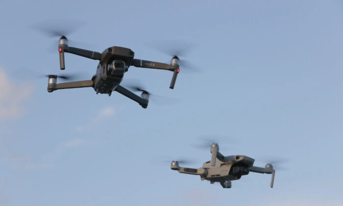 Um DJI Mavic 2 Pro e um DJI Mavic Mini feitos pelo fabricante chinês de drones voam próximos um do outro em Miami, Flórida, em 15 de dezembro de 2021. (Joe Raedle/Getty Images)