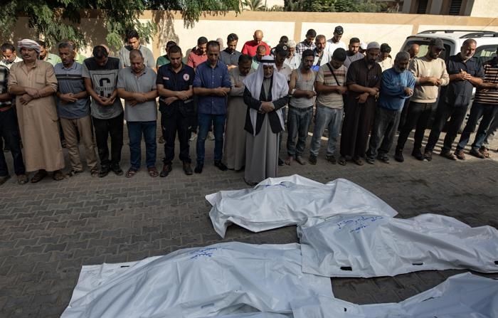 Palestinos rezam diante de corpos no Hospital Europeu em Khan Younis, no sul da Faixa de Gaza, em 2 de outubro de 2024 (EFE/EPA/HAITHAM IMAD)