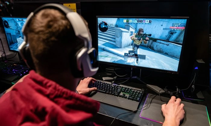 Um participante senta-se em um monitor de computador para jogar um videogame no festival de videogame DreamHack de 2019 em Leipzig, Alemanha, em 15 de fevereiro de 2019 (Jens Schlueter/Getty Images)
