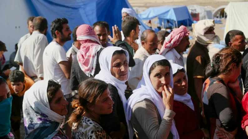 Iraquianos deslocados da comunidade Yazidi se reúnem para receber ajuda humanitária no campo Nowruz, em Derike, Síria, em 12 de agosto de 2014. (AP Photo/ Khalid Mohammed)