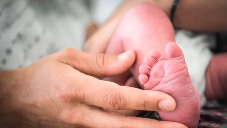 Uma mulher segura o pé de um bebê em uma foto de arquivo sem data (Loic Venance/AFP via Getty Images)