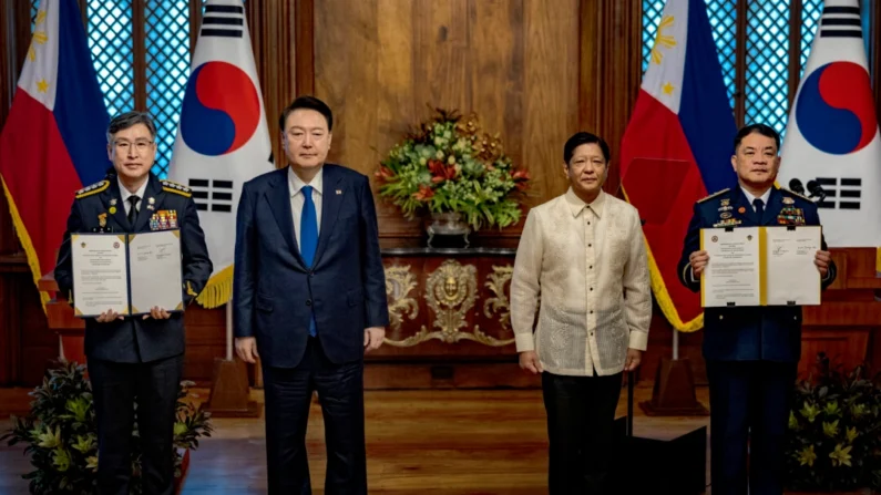 O presidente filipino Ferdinand Marcos Jr. (2º à direita) e o presidente sul-coreano Yoon Suk Yeol (2º à esquerda) posam para fotos enquanto Kim Jong-uk (à esquerda), comissário geral da guarda costeira coreana, e Ronnie Gil Gavan, comandante da guarda costeira filipina, seguram acordos assinados durante uma reunião no Palácio Malacanang em Manila, Filipinas, em 7 de outubro de 2024. Yoon está nas Filipinas em uma visita diplomática de parceiros da ASEAN (Ezra Acayan/Getty Images)
