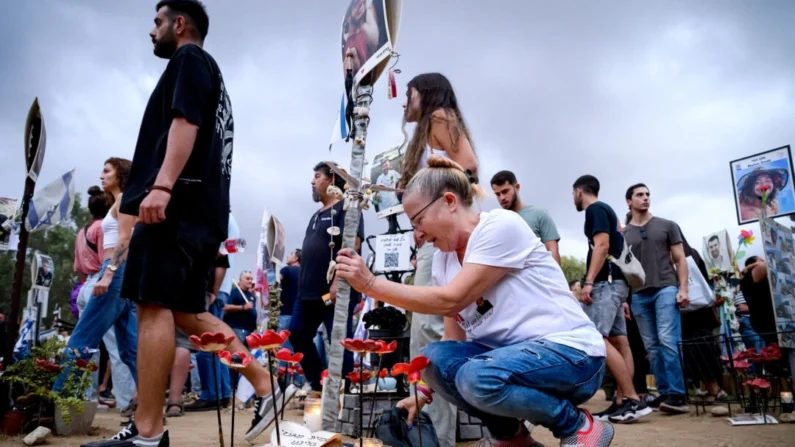 Uma mulher desaba no memorial a Amit Magnezi enquanto familiares e amigos dos falecidos e sequestrados se reúnem no local do Festival Nova para marcar o aniversário de um ano dos ataques do Hamas, em Re'im, Israel, em outubro de 2019. 7, 2024. (Leon Neal / Imagens Getty)