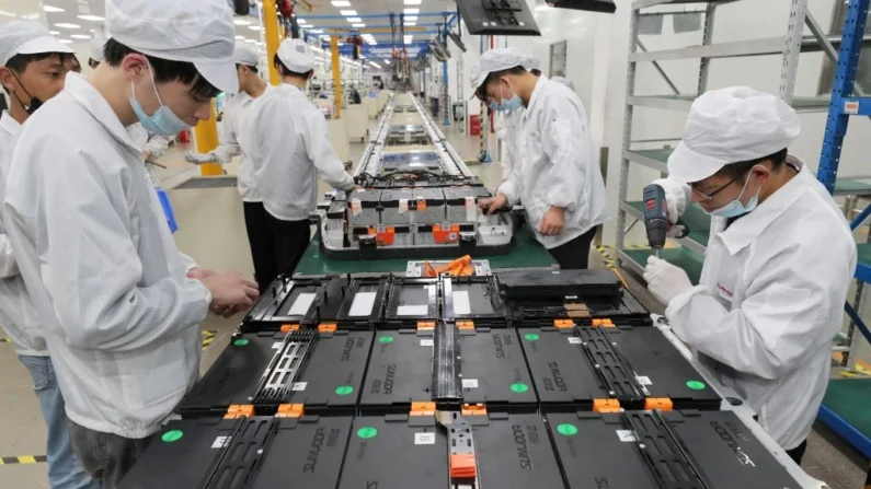 Esta foto tirada em 12 de março de 2021 mostra trabalhadores em uma fábrica da Xinwangda Electric Vehicle Battery Co. Ltd, que produz baterias de lítio para carros elétricos e outros usos, em Nanjing, na província de Jiangsu, no leste da China. - China OUT (Foto da AFP) / China OUT Foto de STR/AFP via Getty Images
