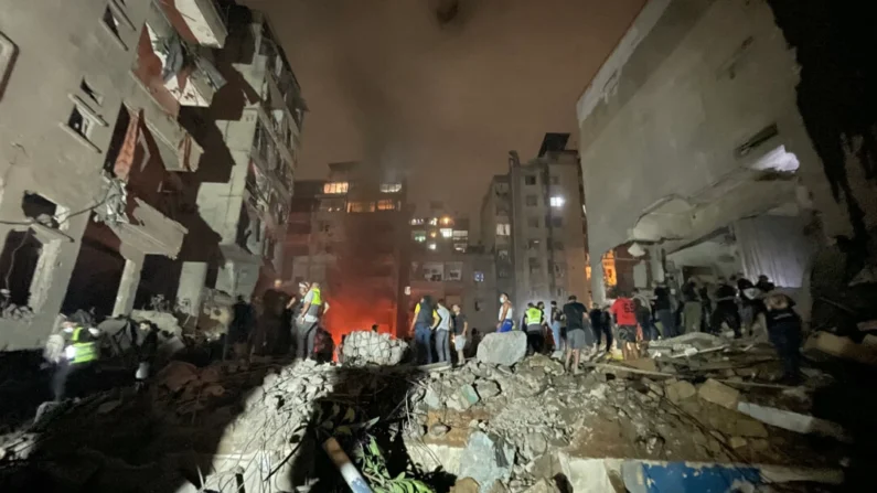 Membros da defesa civil libanesa e outras pessoas inspecionam o local de um ataque aéreo israelense no bairro de Basta, em Beirute, em 10 de outubro de 2024 (Hassan Fneich/AFP via Getty Images)
