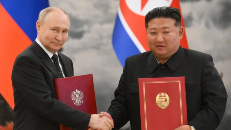 O líder russo, Vladimir Putin, aperta a mão do líder da Coreia do Norte, Kim Jong Un, após uma cerimônia de assinatura após suas negociações bilaterais na residência estatal de Kumsusan, em Pyongyang, em 19 de junho de 2024 (Kristina Kormilitsyna/AFP via Getty Images)
