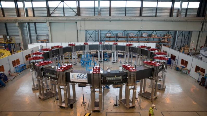 Um trabalhador passa pela bobina de campo poloidal nº 5 do ITER projetada para moldar plasma e destinada à montagem do Tokamak ITER em Saint-Paul-Lez-Durance, sul da França, em 28 de julho de 2020 (AP Photo/Daniel Cole)