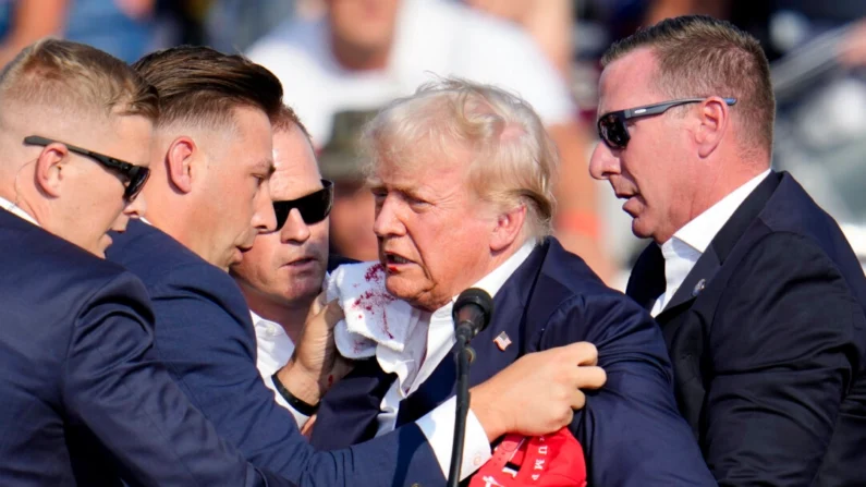 O candidato presidencial republicano e ex-presidente Donald Trump é ajudado a sair do palco em um evento de campanha em Butler, Pensilvânia, em 13 de julho de 2024 (Foto de Gene J. Puskar/AP)