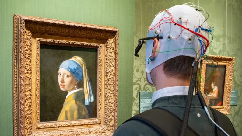 Um participante da pesquisa usa óculos de rastreamento ocular e uma touca de eletroencefalograma (EEG) enquanto vê a obra "Moça com brinco de pérola", de Vermeer, no Museu Mauritshuis, Haia, Holanda (Cortesia de Mauritshuis)