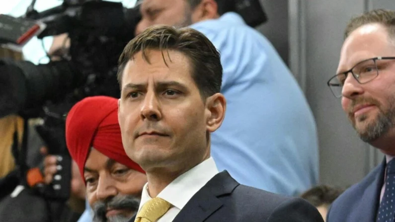 Michael Kovrig se levanta enquanto ele e Michael Spavor são reconhecidos antes de um discurso do presidente dos EUA, Joe Biden, na Câmara dos Comuns em Ottawa, em 24 de março de 2023. (Mandel Ngan/POOL/AFP via Getty Images)