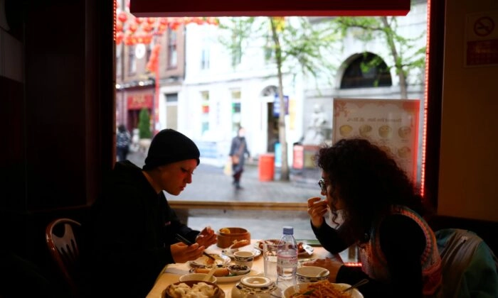 Pessoas sentam-se dentro de um restaurante em Chinatown, Londres, em 18 de maio de 2021. (Hannah McKay/Reuters)