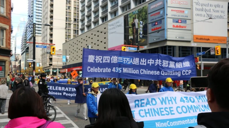 As pessoas assistem a um desfile no centro de Toronto em 2 de novembro de 2024, marcando o 20º aniversário da publicação de “Nine Commentaries on the Communist Party” (Nove comentários sobre o Partido Comunista), um livro que detalha o regime totalitário chinês e as violações dos direitos humanos (Andrew Chen/The Epoch Times)
