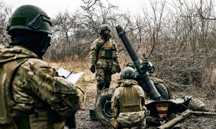 Soldados voluntários se preparam para disparar contra posições russas perto de Bakhmut, na região de Donetsk, na Ucrânia, em 8 de março de 2023 (Libkos/AP Photo)
