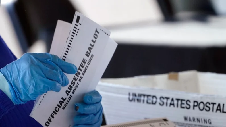 Um funcionário do Conselho de Registro e Eleições do Condado de Fulton processando cédulas de votação ausentes na State Farm Arena em Atlanta em 2 de novembro de 2020. (John Bazemore/AP Photo)