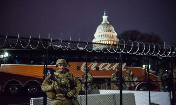 Um Guarda Nacional está do lado de fora da cerca de arame farpado que cerca o Capitólio dos EUA em Washington em 15 de janeiro de 2021. (Liz Lynch/Getty Images)
