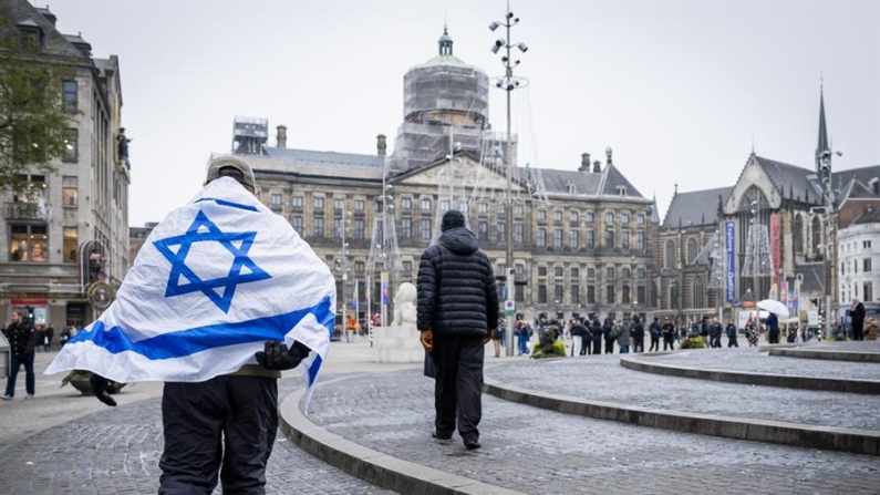  Um homem com uma bandeira israelense nos ombros caminha pela Praça Dam em Amsterdã, Holanda, 08 de novembro de 2024 (EFE/EPA/Remko de Waal)
