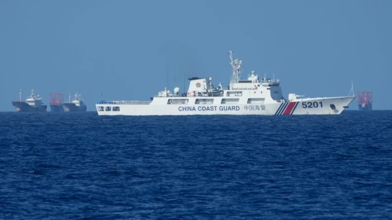 Um navio da guarda costeira chinesa permanece ao lado de navios suspeitos de pertencerem à milícia chinesa perto da ilha de Thitu, localmente chamada de ilha Pag-asa, em 6 de novembro de 2024. Aaron Favila/AP Photo
